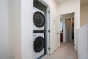 Laundry closet at 5235 Beachfront Cove Unit 102 featuring a modern white stackable washer and dryer unit