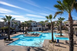 Elevated view of the resort-style pool and spa at the gated Playa Del Sol community, highlighting the luxury lifestyle available at 5235 Beachfront Cove Unit 102.