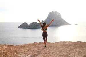 woman in gym wear throwing her hands in the air