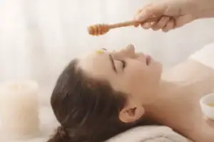 Masque visage naturel au miel cru appliqué sur la peau pour illustrer les bienfaits du miel pour la peau