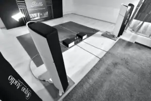 Paire d'enceintes Aequo Audio Stilla vues de haut avec des amplificateurs posés au sol et une moquette en premier plan