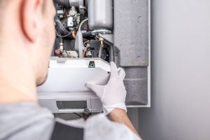 technician installing heating furnace system