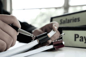 Stack of paper work flanked by folders that read "Salary." 