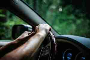 Hands gripping a steering wheel in traffic, the bracing response somatic therapy near me helps the body release.