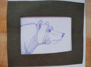 Sketch of a bear head framed on paper, step in a bear drawing tutorial.