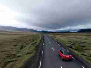 red hatchback vehicle on asphalt road representing letting thoughts go by as a result of doing somatic therapy and nervous system regulation. start somatic therapy in michigan today.