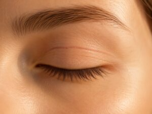 Nahaufnahme geschlossenes Auge mit feiner Lidnarbe – Nachsorge nach Blepharoplastik Lid-OP Augenarzt Wien Dr. Filip FEBO
