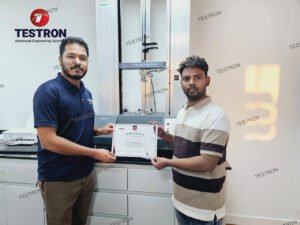 “Testron engineer presenting training certificate to client during Benchtop Universal Tester installation