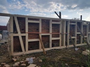 Betonfundament für Wellnesshof RaJa Bauprojekte, Holzrahmenaufbau, nachhaltige Bauweise, modernes Design, hochwertiges Bauholz, natürliche Materialien, Gartenumgestaltung, Wellness-Oase, entspannende Rückzugsorte, Naturverbundenheit.