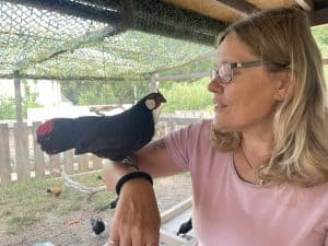 Ente in der Hand einer lachenden Frau auf dem Wellnesshof RaJa, Entspannungs- und Naturerlebnis, Tierkontakt, Tierliebe, nachhaltiger Tourismus, Entspannung und Tierwohl.