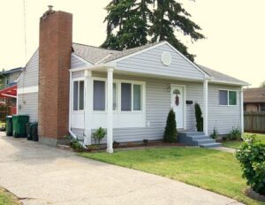 House with brick chimney and green trash cans