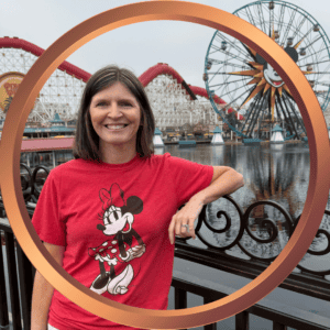 Woman smiling with Minnie Mouse shirt at Disneyland amusement park.