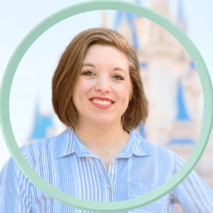 Woman smiling at Disney castle, enjoying a vacation.