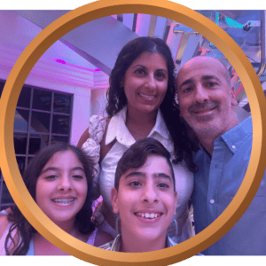 Family smiling together at a vacation resort with vibrant lighting and modern decor.