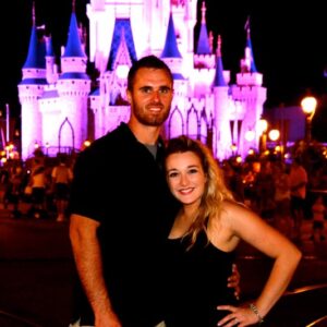 Disney castle illuminated at night with visitors in the foreground, perfect for Florida family vacation keywords.