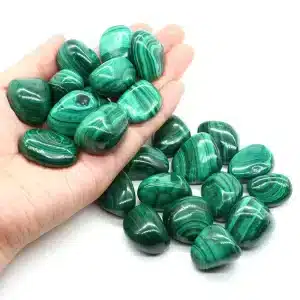 A collection of smooth, glossy Malachite tumbled stones with characteristic swirls and concentric bands of light and dark green.