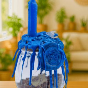 Healing Spell Jar - Large, a glass jar with a blue candle melting over a witch's pentagram charm, with blue wax drippings covering the jar and candle, used for spiritual healing and positive energy.