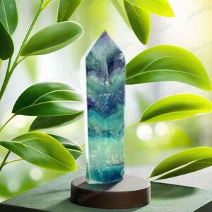 Fluorite Crystal Point, a vibrant green and purple mineral crystal with a pointed tip, displayed on a wooden surface between wooden triangular supports.
