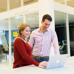 Dos profesionales revisan una campaña digital en un entorno de oficina moderno, representando satisfacción y colaboración.