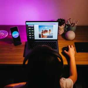 Diseñadora digital creando contenido en Canva desde su escritorio con luz ambiental y herramientas creativas para mejorar su presencia digital.
