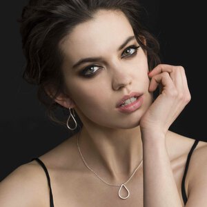 Modellbilde av sølvdråper ørepynt og halskjede