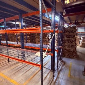 Estantería industrial azul y naranja con largueros metálicos y rejillas de apoyo.