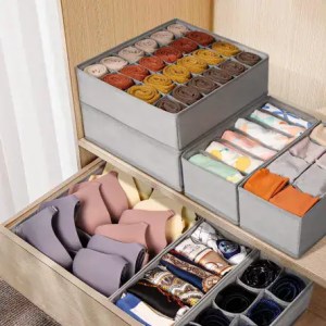 Colorful rolled socks and neatly folded accessories organized in storage boxes for easy access and style.