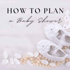 White baby shoes with pearl accents and decorative flowers for a baby shower celebration.