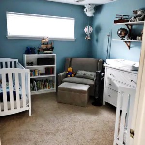 Cozy baby nursery with white crib, bookshelf, plush toys, and calming blue walls, creating a peaceful space for infants and parents. Perfect for restful sleep and early childhood development.