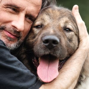 man hugging senior dog