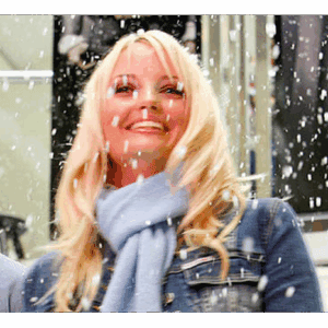 Woman enjoying fake snow at an outdoor winter event in Los Angeles.
