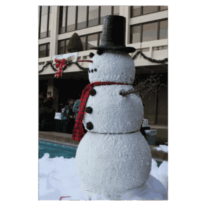 Snowman decoration with top hat, scarf, and buttons at winter event.