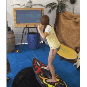 Child playing virtual surfing game on a large screen.