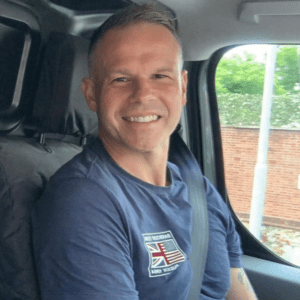 Martin Wicks sitting in van seat. Smiling and introducing his central heating and repair services.