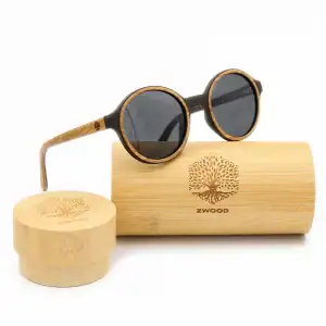 Lunettes de soleil rondes Zwood® en bois clair et monture noire avec étui en bambou sur fond blanc