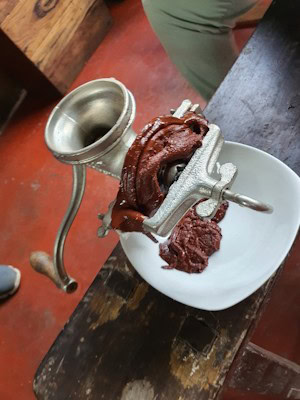 Manually grinding the cacao beans into chocolate