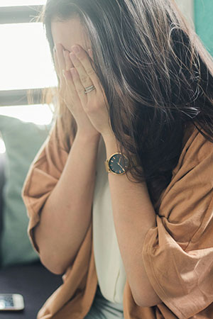 The girl cries and covers her face with her hands