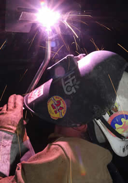 Image of a person welding with a DuraFlux MIG gun while welding over their head