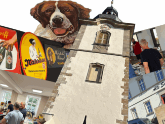 Eine Collage zeigt alte Bierschilder, eine Illustration eines Bernhardinerhundes, einen hohen Kirchturm, Männer, die in einem hellen Raum auf Tischen in Sammlerstücken stöbern, und das Äußere der "Alten Schule", alles kunstvoll arrangiert in einem automatisch gespeicherten Entwurf mit Weißraum.