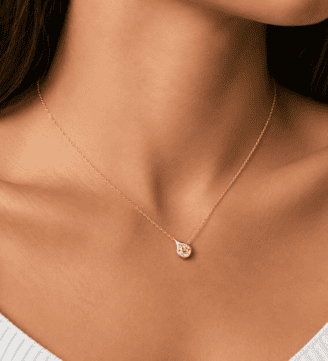 Velrose Droplet Necklace in gold finish worn by a model, featuring a round brilliant moissanite pendant in 925 sterling silver.
