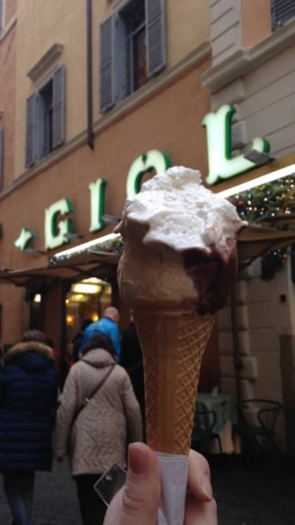 gelato cone close up with the gelateria in the background