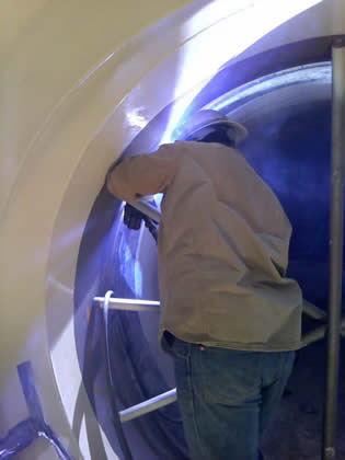 Image of a person welding inside a pipe