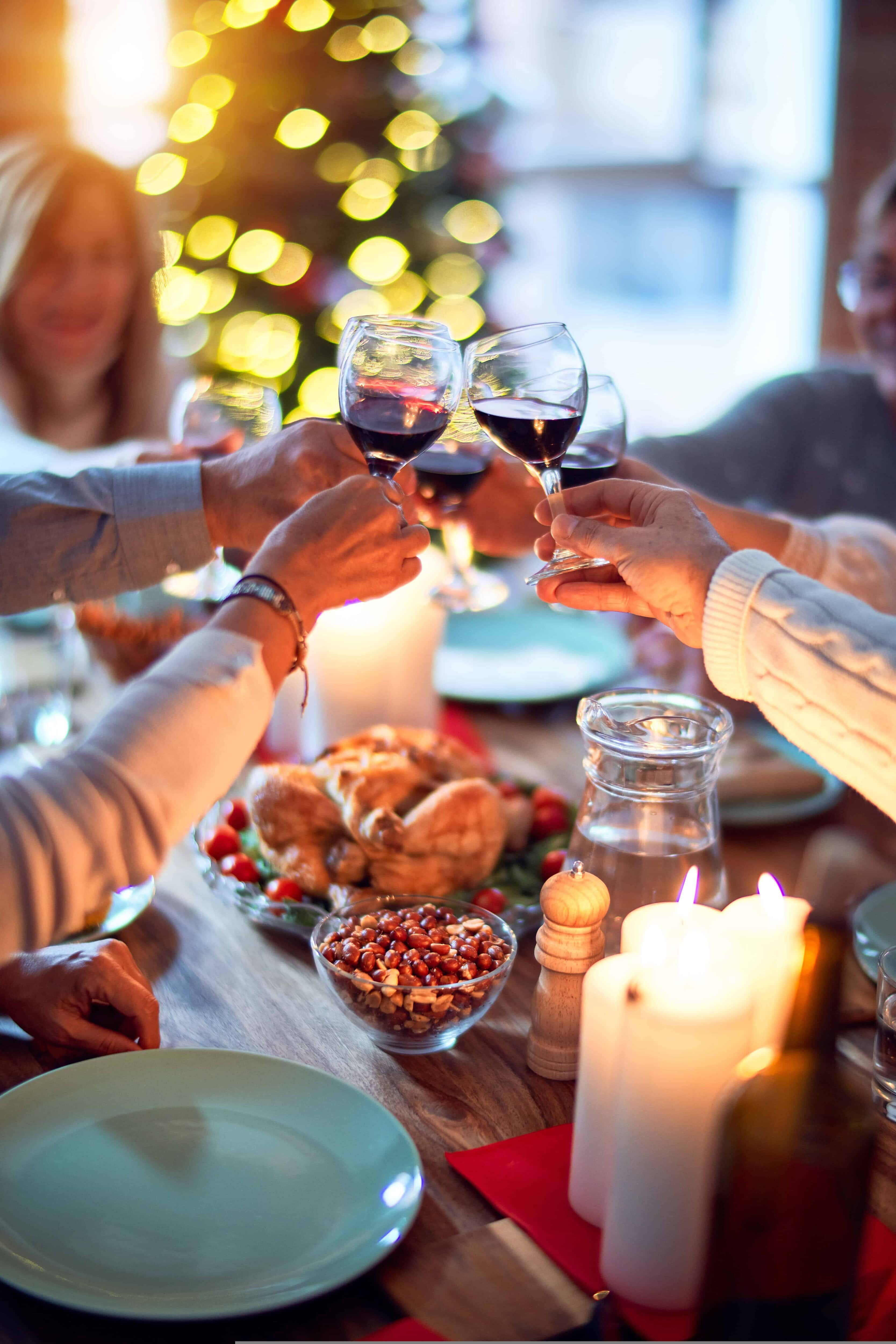 People at a dinning table with wine glasses saying cheers