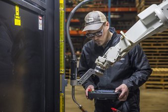 Welder using a teach pendant to program a welding robot