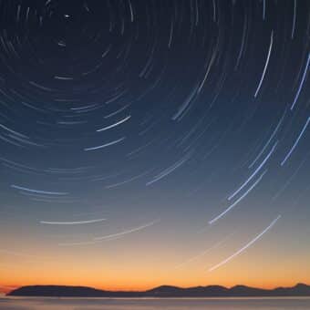 A timelapse photo of stars over a horizon