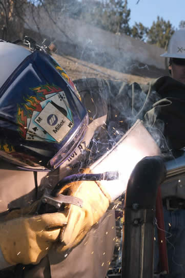 Image of welder using a Dura-FluX MIG gun, welding in the hot Arizona sun at Hot AZ Hell Welding and Fabrication