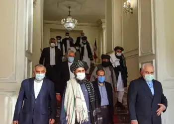 An image shows former Iranian Foreign Minister Mohammad Javad Zarif meeting with Taliban official Mullah Abdul Ghani Baradar in Tehran last year