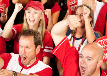 Watching a sports match inside the stadium is associated with physiological synchrony among fans