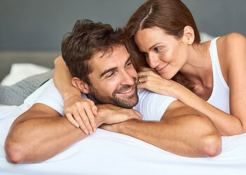 A man and woman laying on a bed