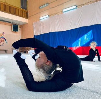 Гимнастки выполняют упражнения на растяжку во время тренировки